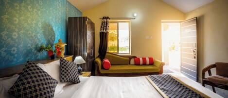 Un dormitorio con cama, sofá, ventana y puerta.