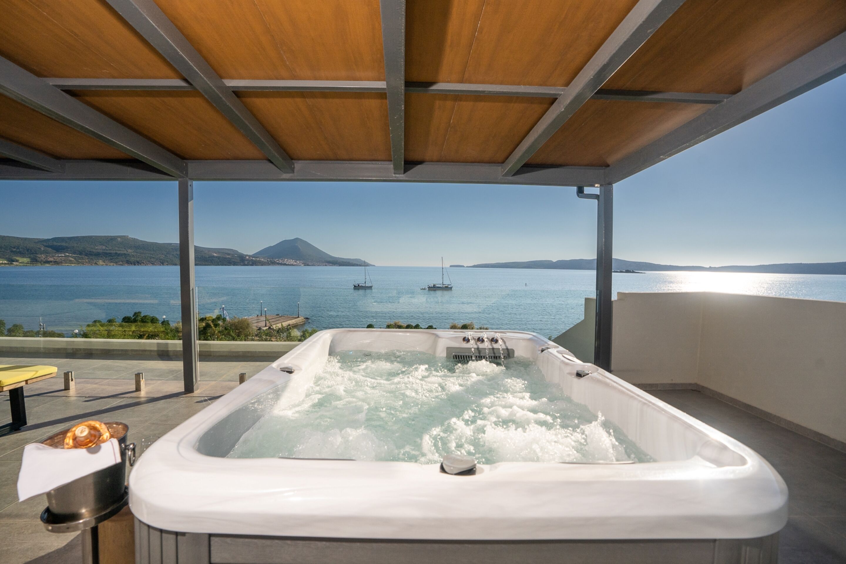 A hot tub with a view of the sea and boats.
