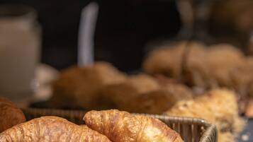 A buffet with various baked goods, including croissants and other pastries.