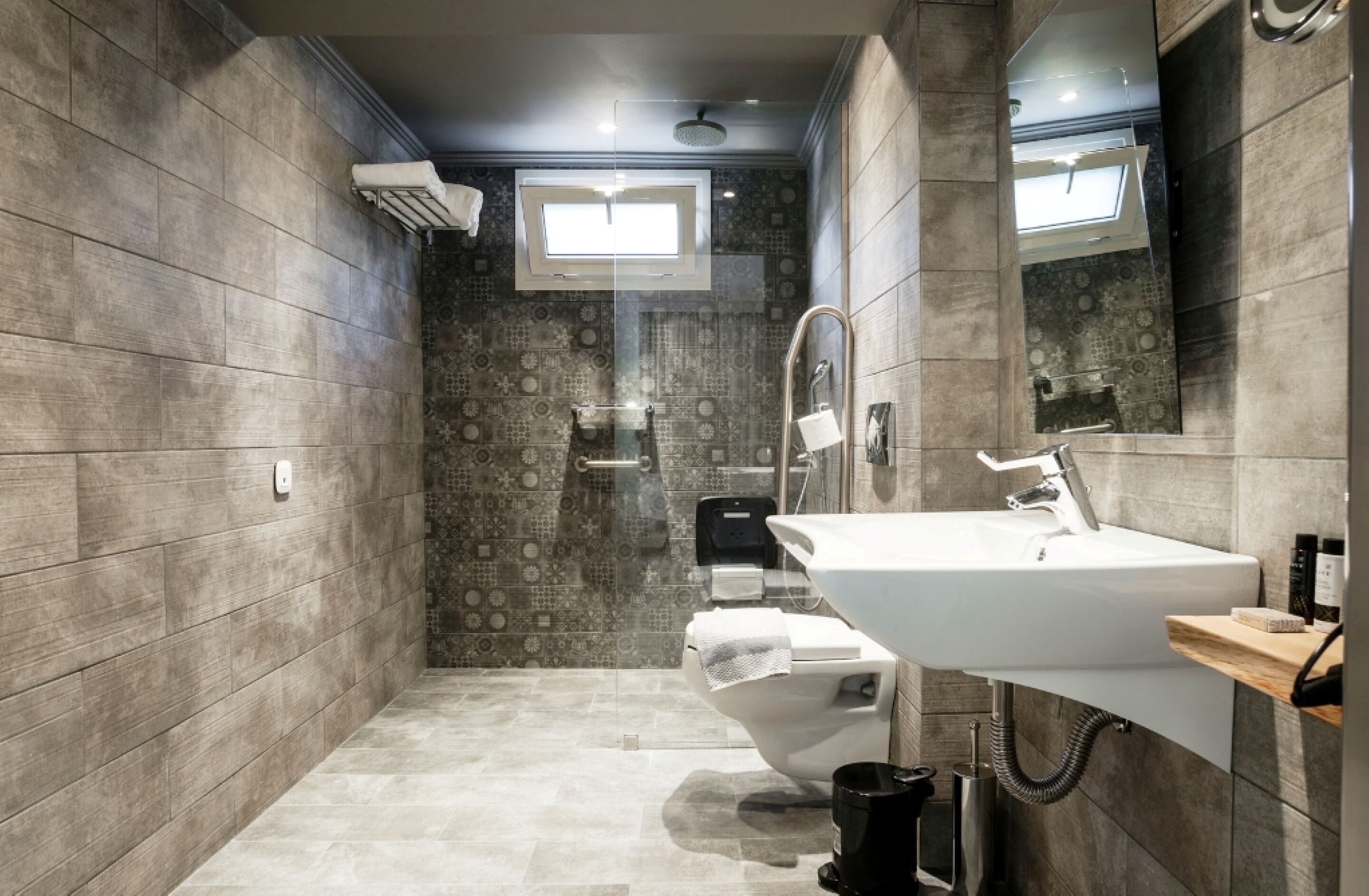 A modern bathroom with a shower, toilet, and sink.