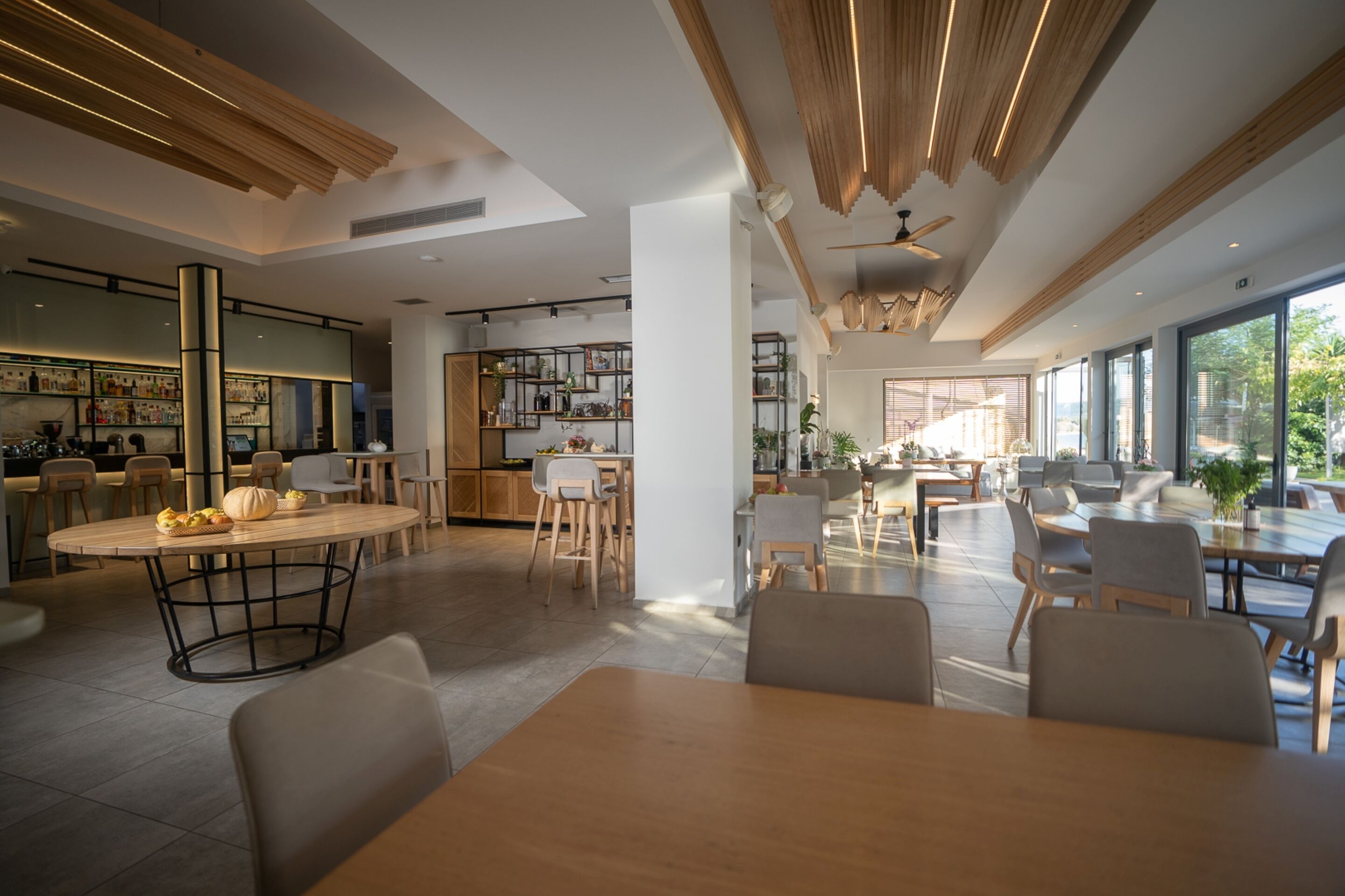 A spacious, modern interior with a central dining area, kitchen, and bar area.