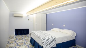 A bedroom with a bed, a wardrobe, and an air conditioning unit. - Casa Niccolo apartment complex (Napoli)