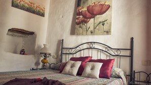Un dormitorio con cama, almohadas, una lámpara y un cuadro en la pared.