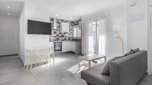 A modern living room with a grey sofa, a small white table, and a white chair. - Rental unit in Port de Sagunt · ★4.60 · 3 bedrooms · 3 beds · 2 baths (Port de Sagunt)