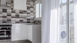 A modern kitchen with white cabinets, a stainless steel oven, a built-in dishwasher, and a large window with a view of the outside. - Rental unit in Port de Sagunt · ★4.60 · 3 bedrooms · 3 beds · 2 baths (Port de Sagunt)
