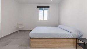 A bedroom with a bed, a chair, and a window. - Rental unit in Port de Sagunt · ★4.60 · 3 bedrooms · 3 beds · 2 baths (Port de Sagunt)
