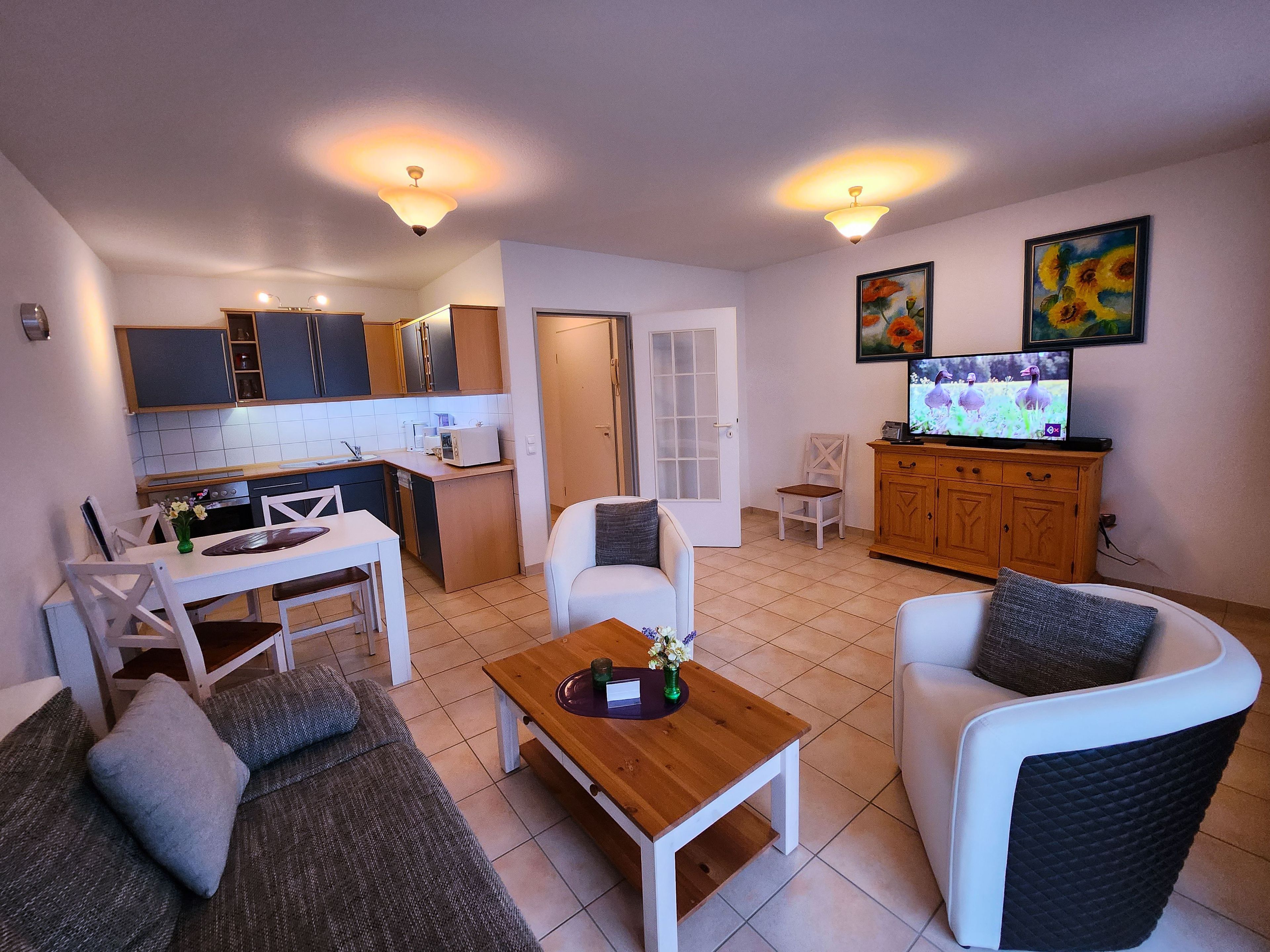 Un espacio habitable compacto con kitchenette, comedor y zona de estar.