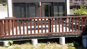 Un bâtiment moderne doté d’une terrasse en bois et de grandes fenêtres.
