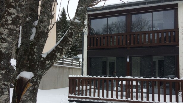Un bâtiment à deux étages doté d’un balcon et dont le sol est recouvert de neige.