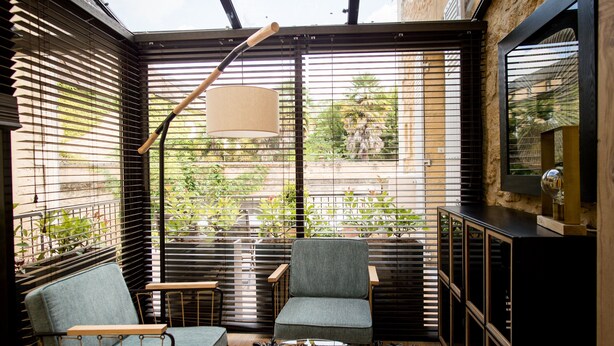 A cozy seating area with two chairs and a small table, a lamp, and a TV on a cabinet. - Elisabeth's suite in the heart of the medieval center of Sarlat (Sarlat-la-Canéda)