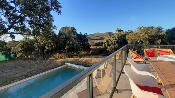 A poolside area with a view of a hilly landscape, outdoor seating, and a clear sky. - Villa Rossa, Contemporary Heated pool  (PALASCA)
