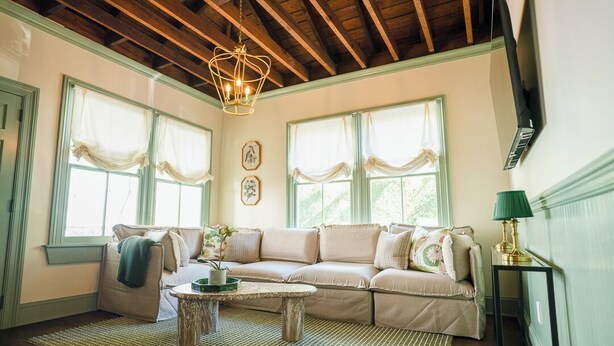 A cozy living room with a sectional sofa, a coffee table, and a chandelier.