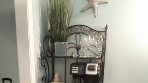 A corner shelf with a coffee maker, a mug, a plant, and a star decoration. - Come on down for a great fishing and beach get away at Benjamin's Pier! (Rockport)