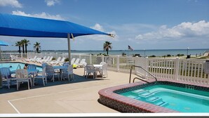 A pool area with lounge chairs, a small pool, and a view of the ocean. - Come on down for a great fishing and beach get away at Benjamin's Pier! (Rockport)