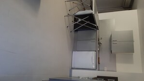A compact kitchen with a built-in refrigerator, a microwave, and a small sink. - F2, air conditioned all comfort (Fréjus)