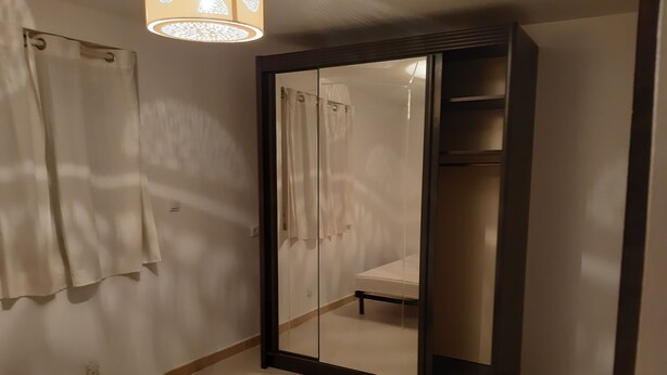A bedroom with a large mirror, a bed, and a wardrobe. - F2, air conditioned all comfort (Fréjus)