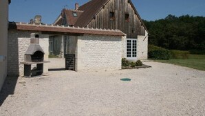 A rustic stone building with a wooden barn, a stone oven, and a gravel driveway. - Château Bizard, 19 p,pool, near castles (Monthou-sur-Cher)