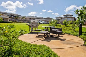 Enjoy al fresco dining and relaxation in this serene outdoor space with a barbecue grill, picnic tables, and comfortable seating.