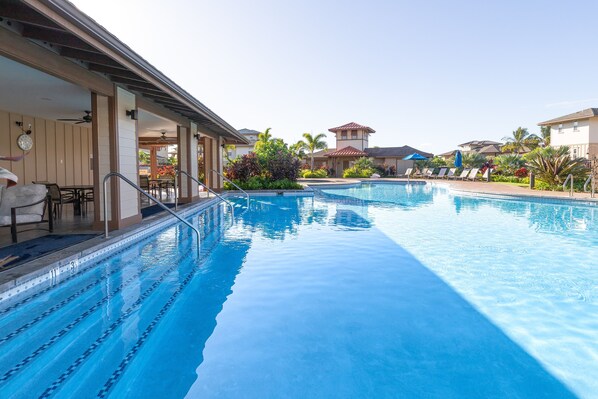Relax by the pool surrounded by lounge chairs and umbrellas.