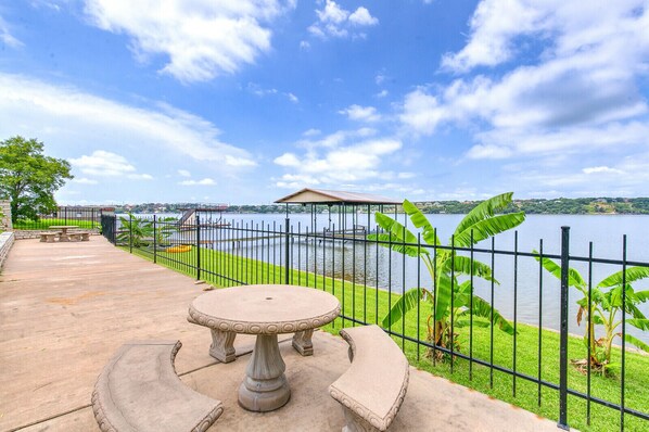 Enjoy serene views of the lake from a tranquil seating area with a stone table and bench.