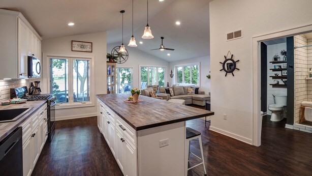 A spacious kitchen with a central island, white cabinetry, and a large window providing natural light. - Blue Fish Cottage-Hot tub, Kayaks, Ice Fishing (Waterford)