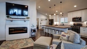 A modern kitchen with white cabinets, a large island, and a built-in oven. - Blue Fish Cottage-Hot tub, Kayaks, Ice Fishing (Waterford)