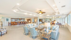 A spacious living area with a dining set, a sofa, and a coffee table. - Oceanfront | Heated Pool-Towers Grande #508 (Daytona Beach Shores)