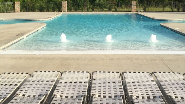 A rectangular swimming pool with clear blue water and two fountains. Surrounding the pool are lounge chairs arranged in rows. - Exquisite 2BR Luxurious Suite Great location in Greenville (Greenville)