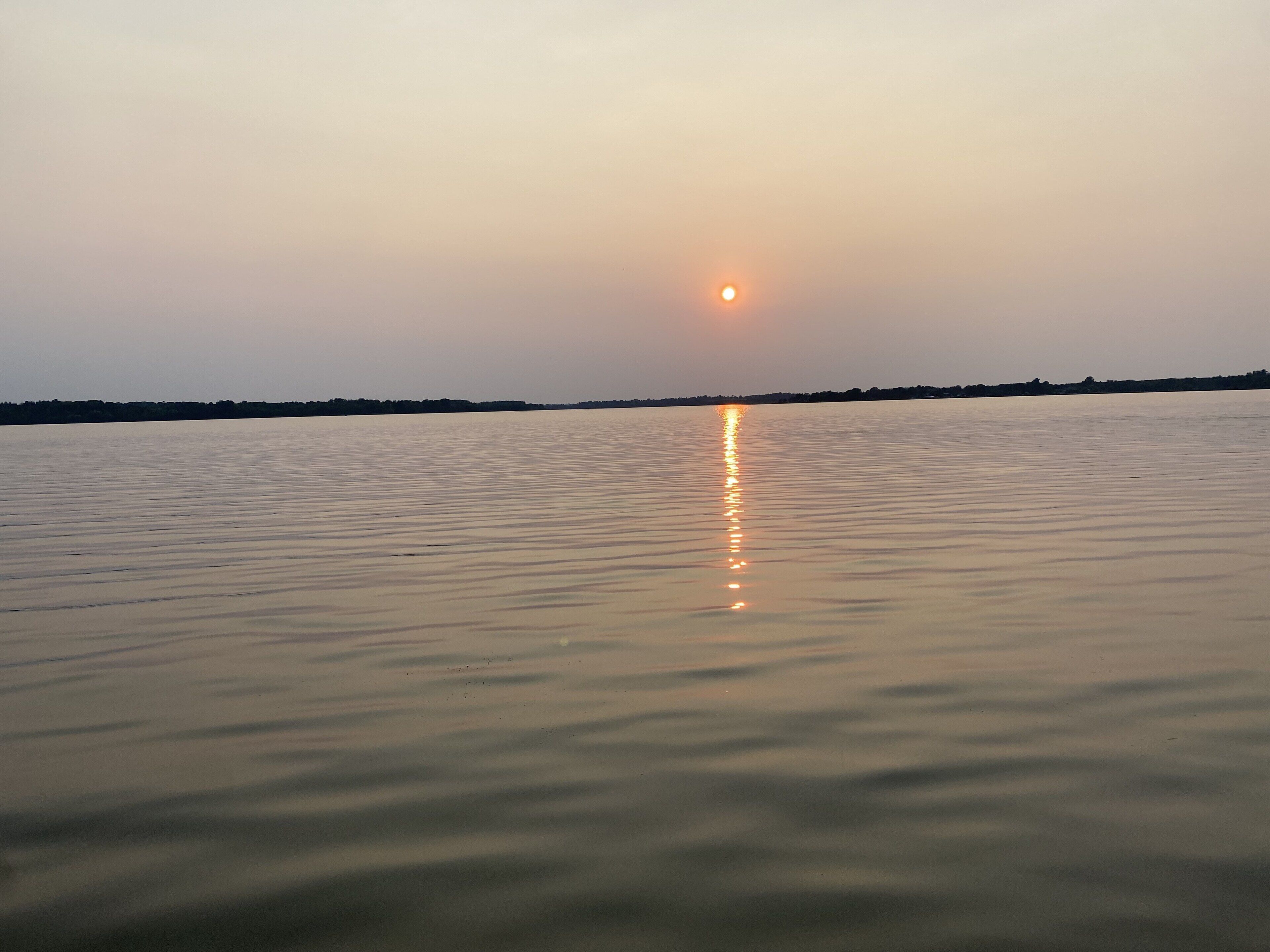 A calm body of water reflecting the sun.