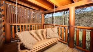 A wooden deck with a swing seat and a wooden fence. - #1  (AMAZING GATED COMMUNITY) - YOUR OWN PRIVATE (SAUNA & HOTTUB) ON BACK DECK (Sevierville)