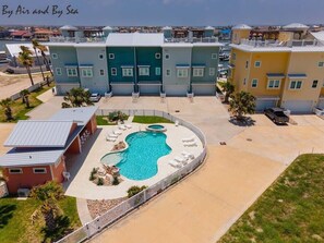 A multi-story residential building with a swimming pool and lounge chairs.