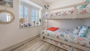 A child's bunk bed with a nautical theme, a window with blinds, a mirror, and a small table with decorative items. - Waterfront Lux Private hot tub & elevator, marina (Port Aransas)