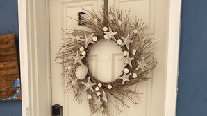 Una porta bianca con una ghirlanda di stelle marine e una maniglia.