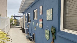 Un edificio blu con diverse finestre e un patio coperto.