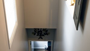 Un escalier en bois mène à une porte surmontée d’une petite fenêtre.