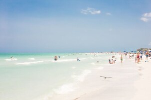 On the beach, white sand, beach umbrellas, beach towels