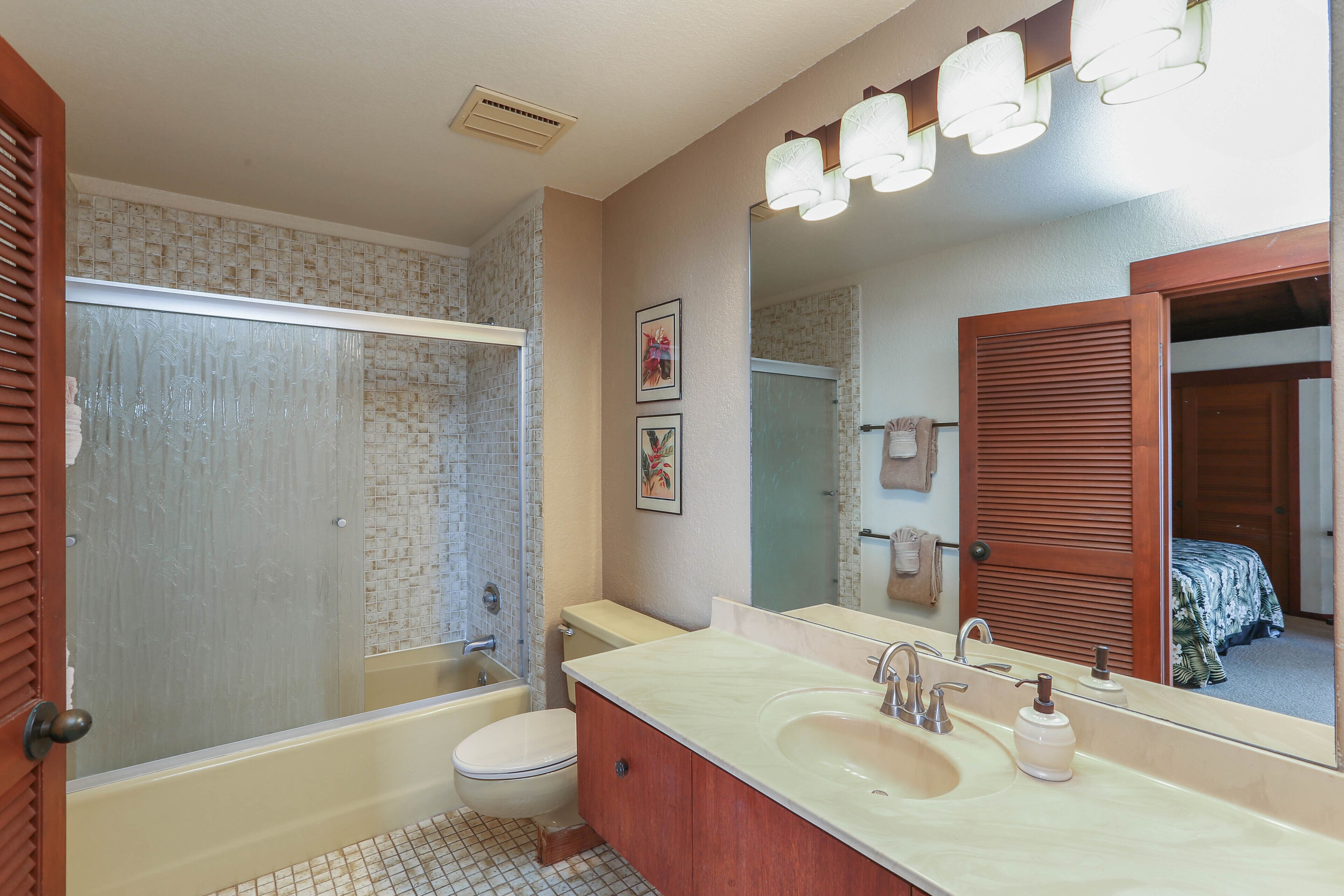 Une salle de bain avec une baignoire, des toilettes, un lavabo et un grand miroir.