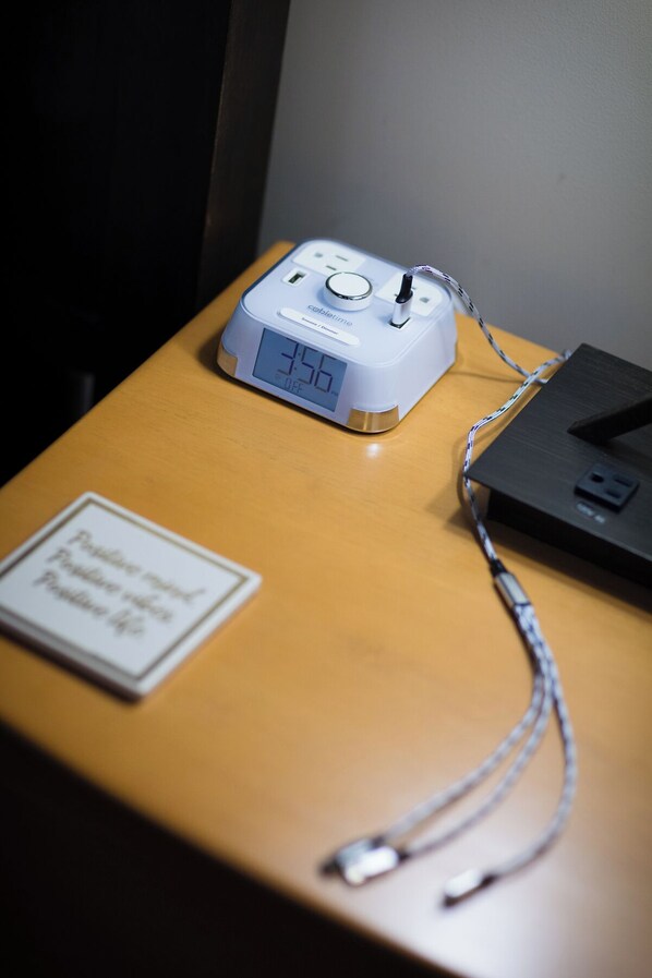 A digital clock displaying 3:50 on a wooden table.