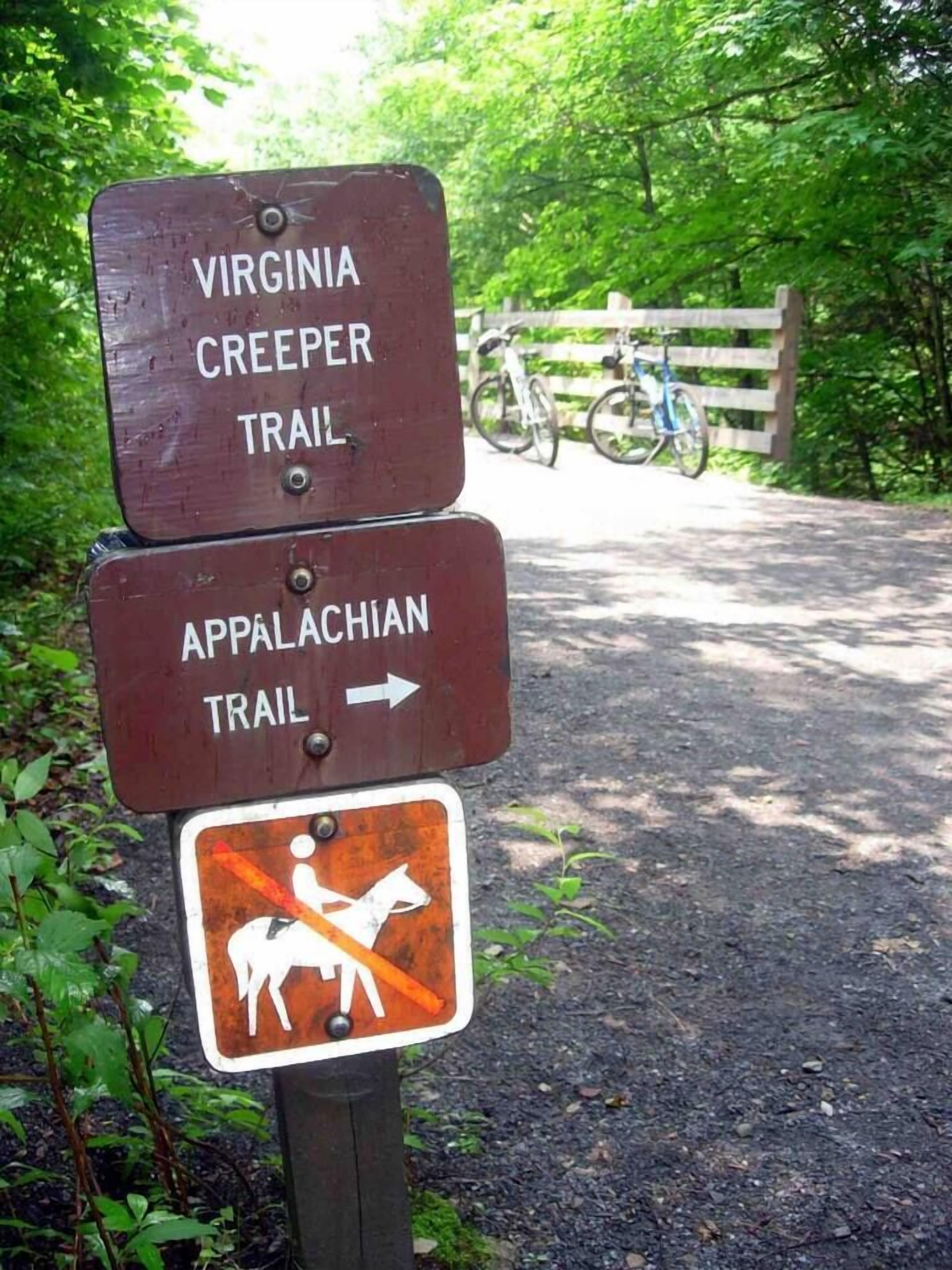 Een bord voor de Virginia Creeper Trail en Appalachian Trail, met een symbool dat paarden verbiedt.