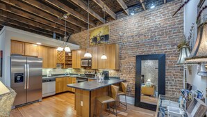 A modern kitchen with wooden cabinets, stainless steel appliances, and a central island with bar stools.