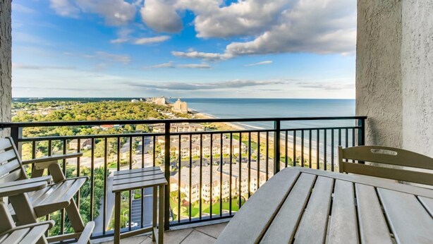 Ein Balkon mit Blick auf das Meer und eine entfernte Burg.