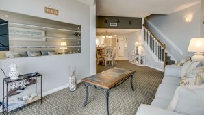 Ein Wohnzimmer mit Sofa, Couchtisch und einer Treppe, die in einen anderen Raum führt.
