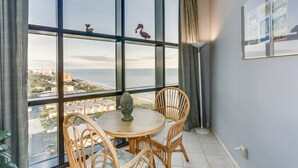 Ein Balkon mit Blick auf die Stadt, Korbstühle, ein kleiner Tisch und eine Lampe.