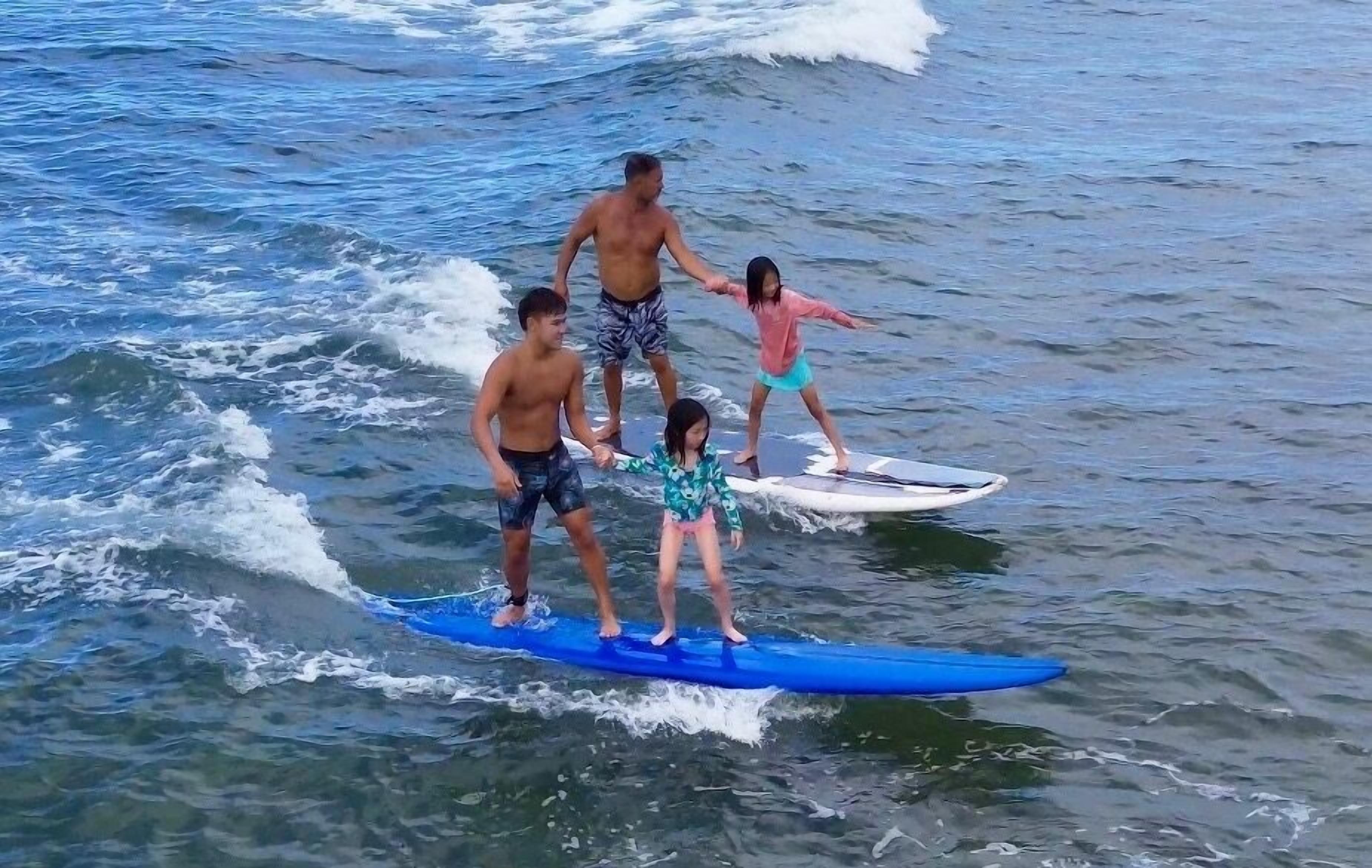 Un gruppo di persone su una tavola da surf nell'oceano.