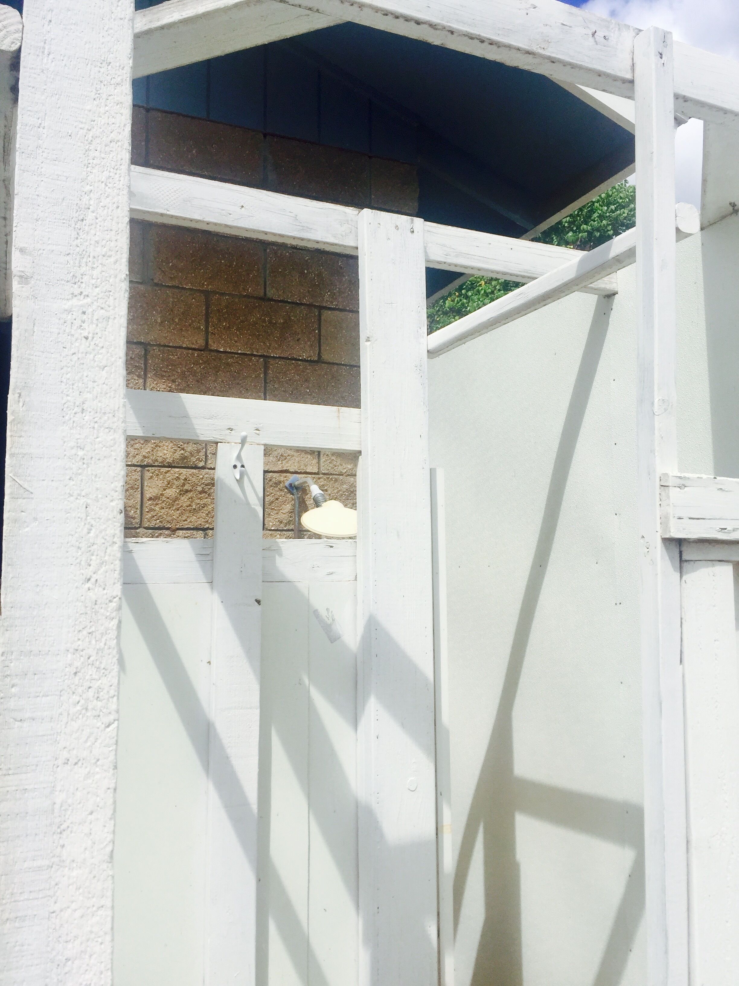 A white wooden structure with a brick wall and a small window.