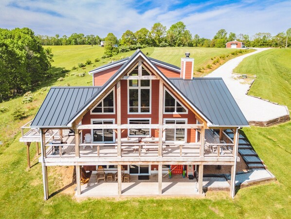 A large, single-story house with a wrap-around porch, a covered deck, and a well-maintained lawn. - Chieftain Meadows 20+ private acres, Hot Tub, Trails, FirePit, Wifi, Game Room (Rockbridge)