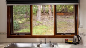 A kitchen with a large window, a sink, and a kettle on the counter. - 2 Bedroom Chalet offers 2 separate bedrooms with a large living/dining area and balcony. (Margaret River)