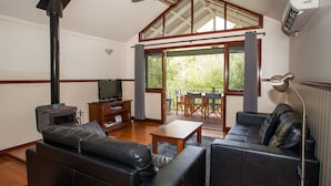 A living room with a fireplace, leather sofas, a television, and a dining area with a table and chairs. - 2 Bedroom Chalet offers 2 separate bedrooms with a large living/dining area and balcony. (Margaret River)