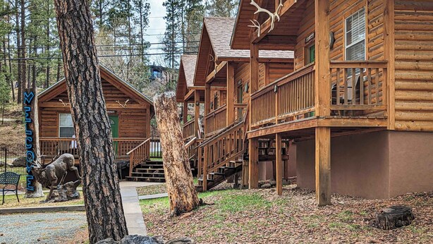 Et hotel i bjælkehytte-stil med flere niveauer, en central trappe og et indbydende skilt.