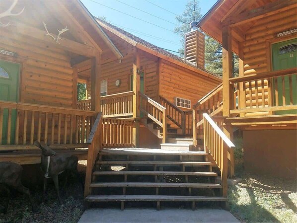 A wooden cabin with a staircase leading to a porch.